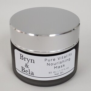 May include: A black jar with a silver lid labeled "Bryn & Bela Pure Vitality Nourishing Mask 50 ml / 1.7 fl oz Net Wt."