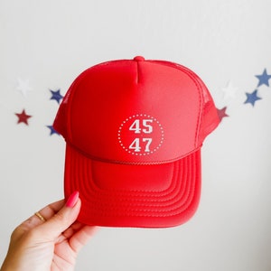 May include: Red mesh trucker hat with a white circle and the numbers "45 47" inside. The hat has a white mesh back.