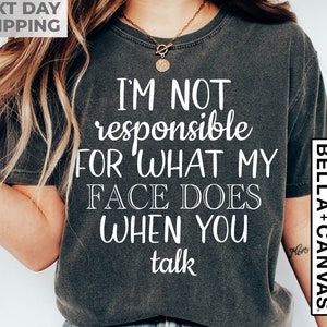 May include: A dark gray t-shirt with white text that reads "I'm not responsible for what my face does when you talk".