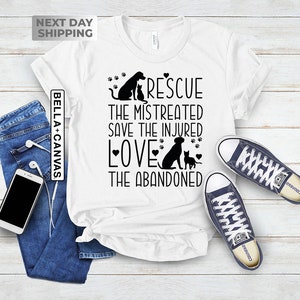 May include: White t-shirt with a black graphic design featuring a dog and cat with the text "Rescue the mistreated save the injured love the abandoned".
