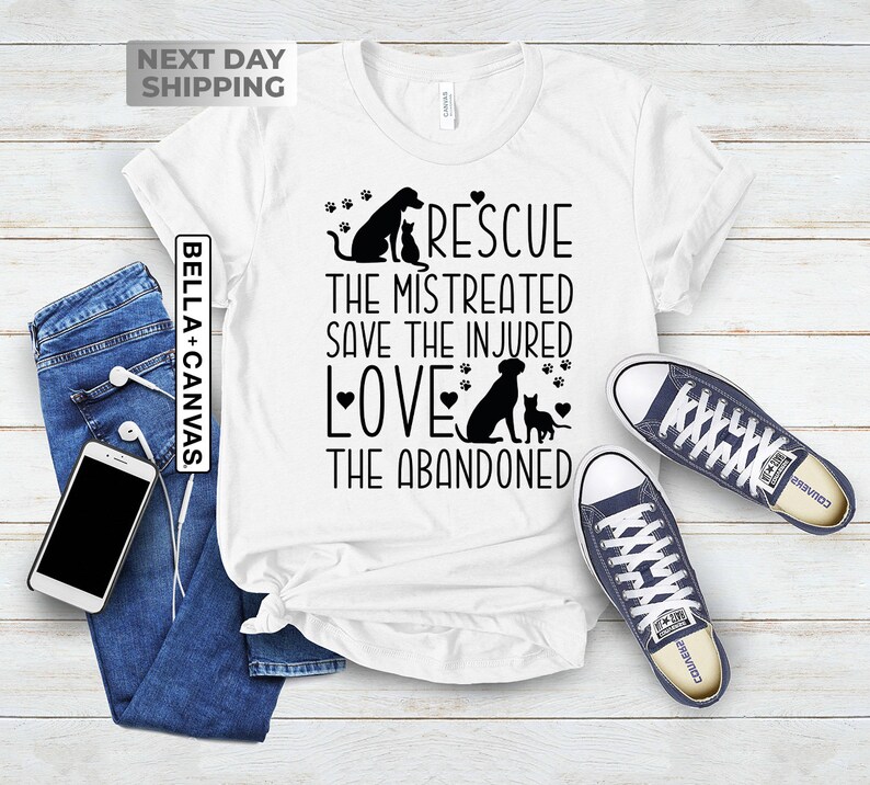 May include: White t-shirt with a black graphic design featuring a dog and cat with the text "Rescue the mistreated save the injured love the abandoned".