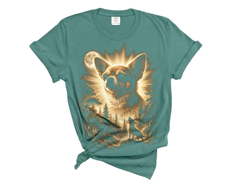 May include: Teal-colored t-shirt featuring a detailed illustration of a Chihuahua dog with a radiant halo, set against a forest and moon backdrop. The design includes a smaller dog silhouette. A unique graphic tee.