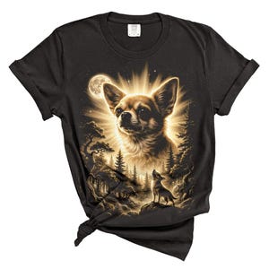 May include: Black t-shirt featuring a detailed illustration of a Chihuahua dog with a radiant halo, set against a moonlit forest scene. The design includes a smaller dog silhouette howling at the moon, creating a striking contrast.