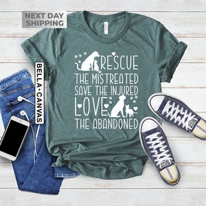 May include: Teal t-shirt with a white graphic design featuring a dog and cat with the text "Rescue the mistreated, save the injured, love the abandoned".