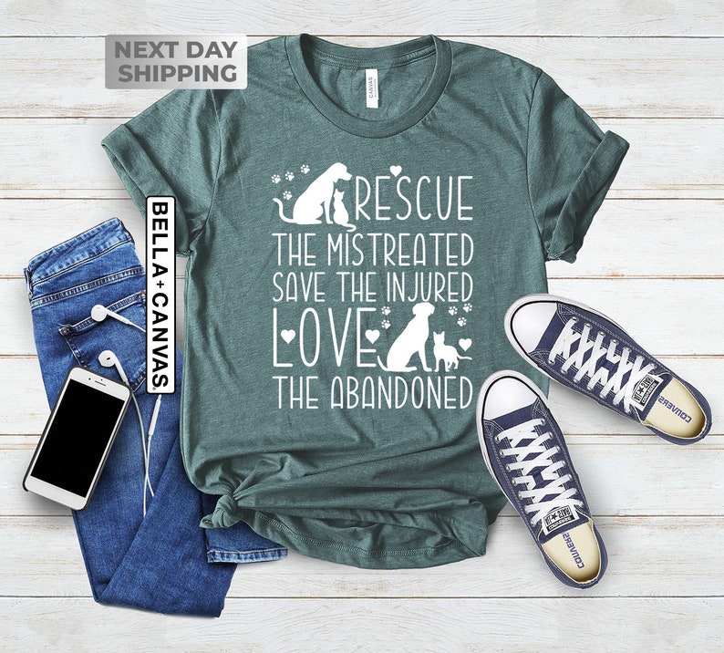 May include: Teal t-shirt with a white graphic design featuring a dog and cat with the text "Rescue the mistreated, save the injured, love the abandoned".