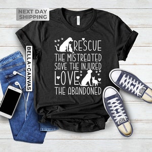May include: Black t-shirt with a white graphic design featuring a dog and cat with the text "RESCUE THE MISTREATED SAVE THE INJURED LOVE THE ABANDONED".