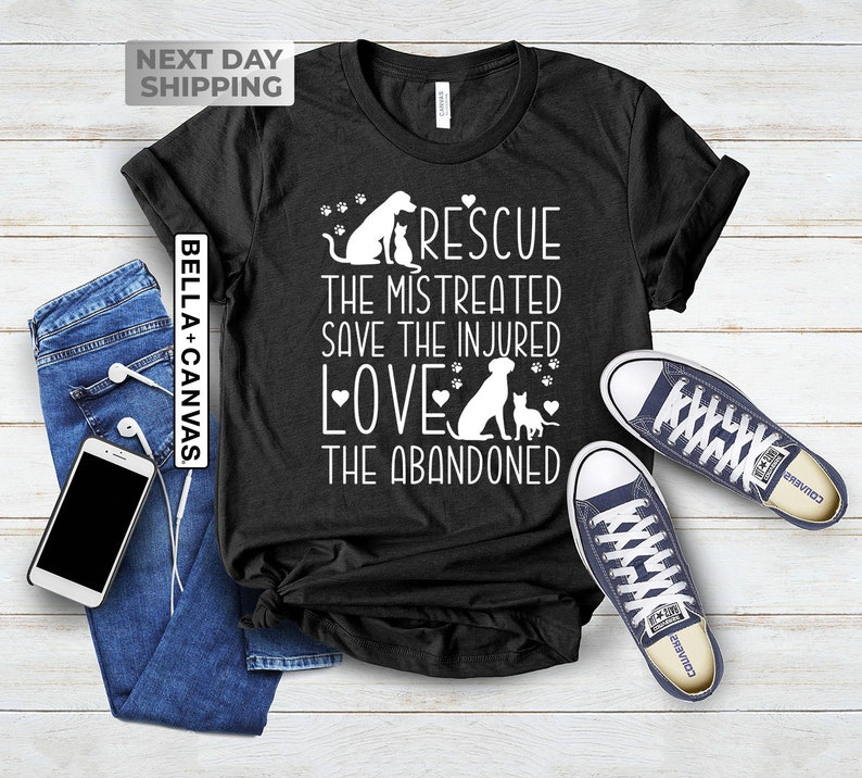May include: Black t-shirt with a white graphic design featuring a dog and cat with the text "RESCUE THE MISTREATED SAVE THE INJURED LOVE THE ABANDONED".