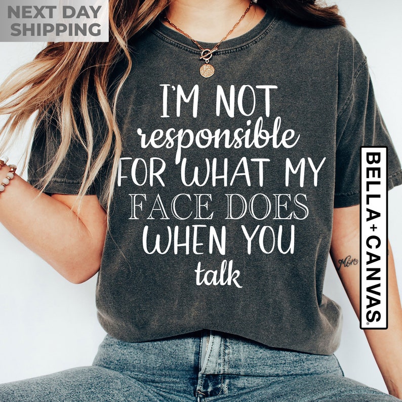 May include: A dark gray t-shirt with white text that reads "I'm not responsible for what my face does when you talk".