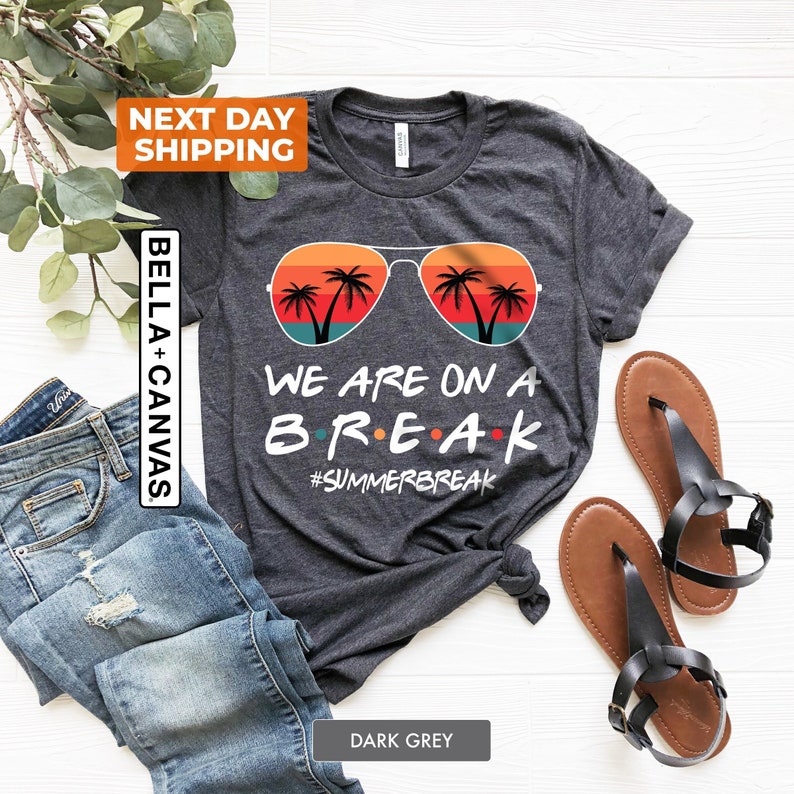 Op de afbeelding: Donkergrijs T-shirt met een afbeelding van een zonnebril met palmbomen en de tekst "We are on a BREAK #SUMMERBREAK"