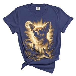 May include: Navy blue t-shirt featuring a detailed illustration of a Chihuahua dog with a radiant glow, set against a forest and moonlit sky. A smaller dog is howling at the moon. The design is printed on a soft, comfortable tee.