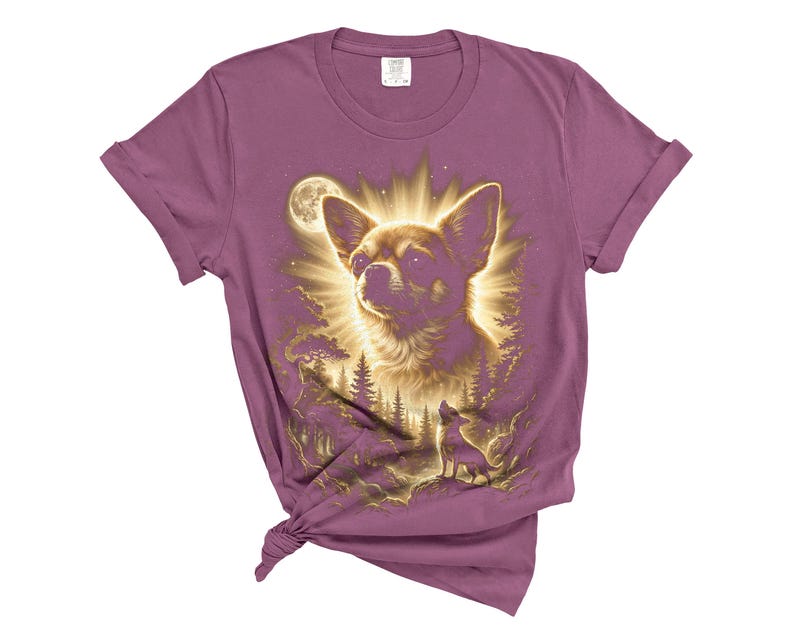 May include: A mauve-colored t-shirt featuring a detailed illustration of a Chihuahua dog with a radiant halo effect, set against a forest and moonlit sky. A smaller dog silhouette is also visible. The shirt has rolled-up sleeves and a knotted hem.