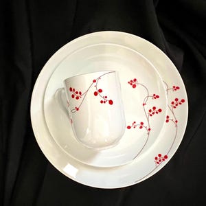 May include: A set of three ceramic mugs with a speckled, matte finish. The mugs are in shades of cream, light gray, and dark gray. Each mug has a simple, minimalist design, perfect for coffee or tea.