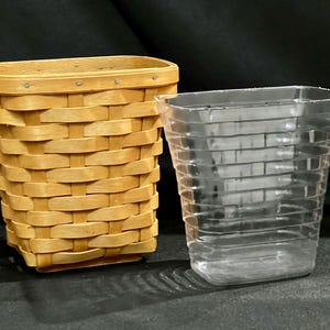 May include: Two containers are displayed against a dark background. On the left is a woven basket with a light brown finish. To the right is a clear plastic container with a brick-like pattern. Both containers are empty.