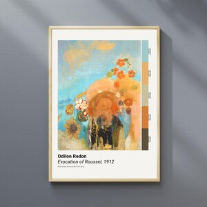 May include: Framed print of Odilon Redon's "Evocation of Roussel, 1912." The artwork features a portrait with a floral arrangement against a blue and orange background. The frame is a light wood color.