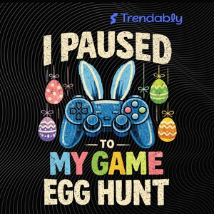 Könnte beinhalten: Schwarzes Grafikdesign mit einem blauen Videospiel-Controller mit Hasenohren und hängenden Ostereiern. Der Text lautet "I PAUSED TO MY GAME EGG HUNT" in verschiedenen Farben. Das Design befindet sich auf schwarzem Hintergrund.