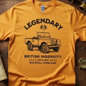 Puede incluir: Camiseta de color mostaza con un gr&aacute;fico negro de un veh&iacute;culo todoterreno cl&aacute;sico. El texto en la camiseta dice "LEGENDARY" encima del veh&iacute;culo y "BRITISH INGENUITY" debajo, con "SINCE 1948" y "SOLIHULL, ENGLAND" debajo.