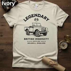 Puede incluir: Camiseta color marfil con una ilustraci&oacute;n negra de un veh&iacute;culo todoterreno vintage. El texto sobre el veh&iacute;culo dice "LEGENDARY", y debajo, "BRITISH INGENUITY SINCE 1948 SOLIHULL, ENGLAND". Tambi&eacute;n hay dos peque&ntilde;as banderas brit&aacute;nicas.