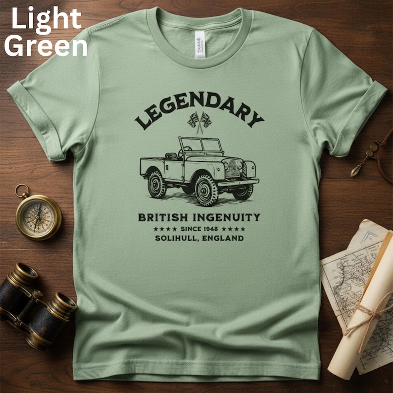 Puede incluir: Camiseta verde claro con un gr&aacute;fico negro de un veh&iacute;culo todoterreno vintage. El texto encima del veh&iacute;culo dice "LEGENDARY" y debajo, "BRITISH INGENUITY SINCE 1948 SOLIHULL, ENGLAND."