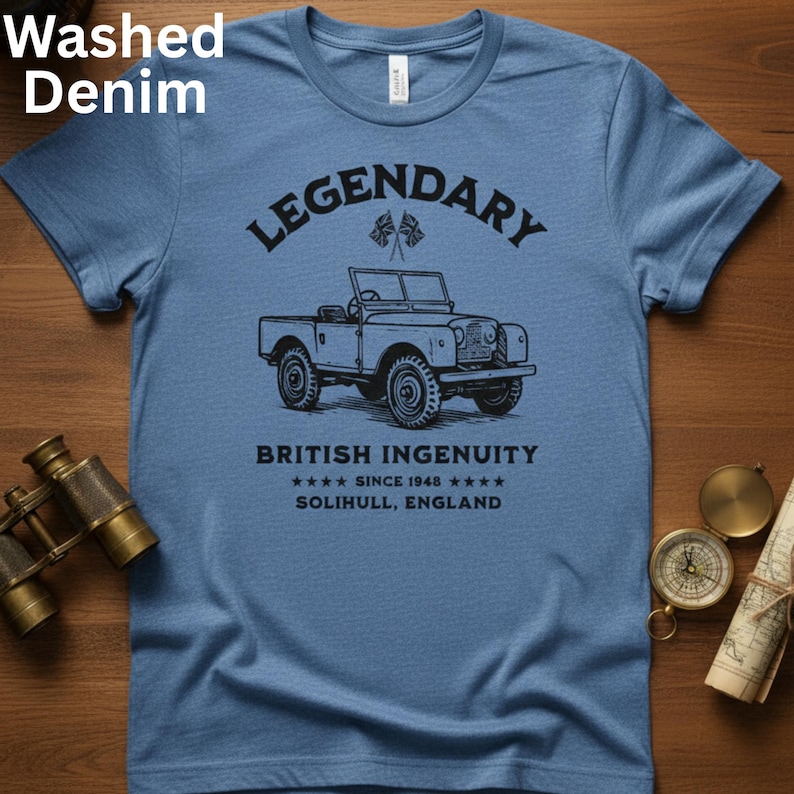 Puede incluir: Camiseta azul denim lavado con la palabra "LEGENDARY" sobre una ilustraci&oacute;n negra de un veh&iacute;culo todoterreno vintage. Debajo, el texto "BRITISH INGENUITY SINCE 1948 SOLIHULL, ENGLAND".