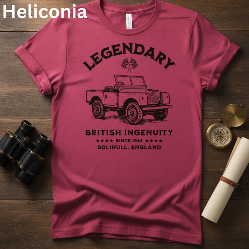 Puede incluir: Camiseta granate con una ilustraci&oacute;n negra de un veh&iacute;culo todoterreno vintage y la palabra "LEGENDARY" encima. El texto "BRITISH INGENUITY" y "SINCE 1948" est&aacute;n debajo. El texto "SOLIHULL, ENGLAND" tambi&eacute;n est&aacute; en la camiseta.