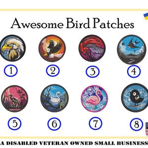 May include: Eight embroidered iron-on patches featuring different bird designs. The patches are circular and have a black outline. The birds are depicted in various colors and poses, including a bald eagle, a cardinal, a raven, a hummingbird, a heron, a swan, a flamingo, and a blackbird. The patches are numbered 1 through 8.