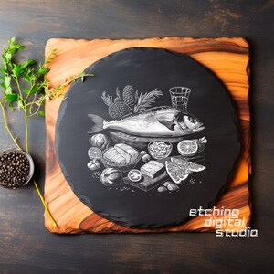 Könnte beinhalten: Ein schwarzes Schiefer-Servierbrett mit einer weißen Linienzeichnung eines Fisches, Gemüses und Kräutern. Das Brett liegt auf einer Holzoberfläche. Der Text "etching digital studio" befindet sich am unteren Rand des Brettes.