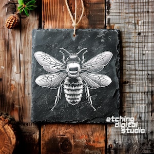 May include: A black slate sign with a white etching of a bee with detailed wings. The sign has the text "etching digital studio" in white lettering at the bottom.