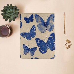 May include: A beige fabric case with a blue butterfly pattern. The butterflies are stylized and have a vintage look.