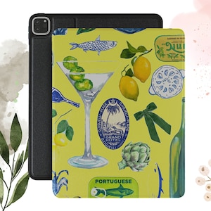 May include: A yellow iPad case with a colorful illustration of a martini glass, lemons, olives, fish, and a green bow. The case also features a blue and white logo that says "DJIDJELLI-PLAGE GRAND HOTEL DJIDJELLI CALGERIE" and the text "PORTUGUESE".