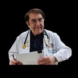 May include: A man wearing glasses, a navy blue shirt, and a white lab coat with a stethoscope around his neck. He is holding a clipboard and pen, smiling at the camera. The lab coat has a gold medal and a patch that reads "American Society for Metabolic and Bariatric Surgery."