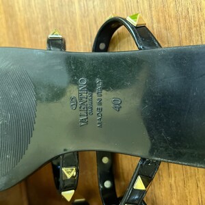 Y2K Valentino Garavani Rockstud Jelly Sandals - Black PVC Thong Flip Flops - Women's Size 40 US 10 - Studded Shoes Made in Italy

Edgy sophistication to your summer wardrobe!
Valentino Garavani Rockstud Jelly Sandals. A cult favorite in the Valentino lineup, these sandals combine the effortless ease of a jelly flip-flop with the high- fashion impact of the iconic pyramid Rockstuds.

Premium high-shine black PVC, these sandals feature the
signature silver-tone studs along the straps.