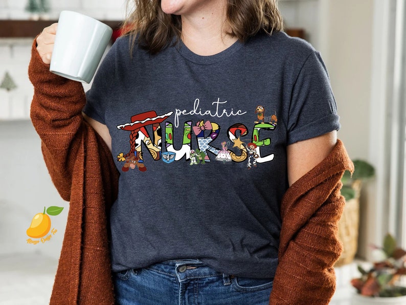May include: A navy blue t-shirt with a white graphic of the word "pediatric" and the word "NURSE" spelled out with characters from the Toy Story franchise.