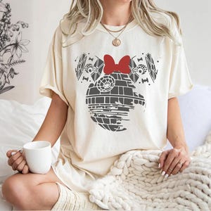 a woman sitting on a bed holding a cup of coffee