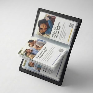 May include: Black leatherette photo album with several open pages. Each page displays a photograph and text. The text includes the questions: "Will you ever see your loved ones who have died?" and "How can you have a happy family?"