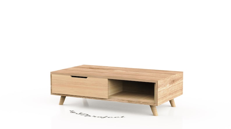 May include: A light wood coffee table with a drawer and a shelf. The table has a simple, modern design with tapered legs.