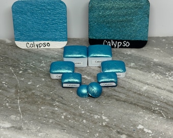 May include: A collection of teal blue paint samples with the word "Calypso" written on each one. The samples are in various sizes and shapes, including squares, rectangles, and circles.