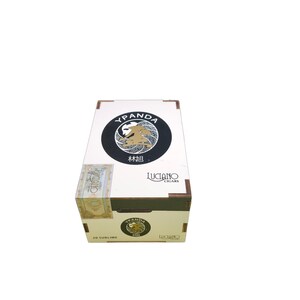 May include: A white rectangular box with the text "YPANDA" and a circular emblem featuring a gold lion. The box also has the text "LUCIANO CIGARS" and "20 SUBLIME".