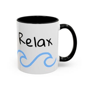 May include: White ceramic mug with a black rim and handle. The mug has the word "Relax" written in black and a blue wave design.