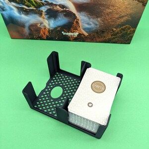 May include: A black card holder with a deck of cards inside. The cards have a white background with a gold circle that says "EARTH".