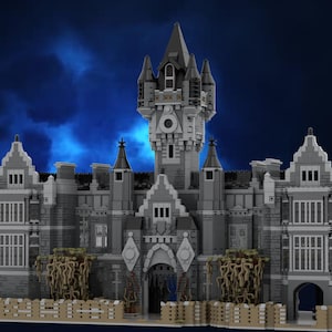 Pode incluir: Modelo detalhado de um castelo cinzento com várias torres, janelas e uma entrada com portão. O castelo apresenta uma torre central com telhado pontiagudo e pequenas torres. O modelo inclui uma cerca de madeira e elementos decorativos, sobre um fundo azul escuro.