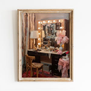 May include: A framed painting depicts a vintage vanity scene. A dark wood vanity table is adorned with makeup, jewelry, and a lamp. A mirror with light bulbs is above the table. A wooden chair sits in front of the vanity, and a pink table with a vase of pink feathers is to the side.