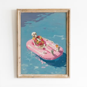 Op de afbeelding: Ingelijste kunstprint met een skelet dat ontspant op een roze zwemband in blauw water. Het skelet draagt een bloemenkrans en houdt een drankje vast. De kunst heeft een vintage, grillige stijl.