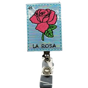 May include: A blue and silver holographic badge holder with a pink embroidered rose and the text "LA ROSA" and the number "41".