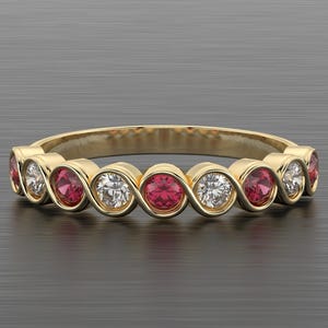 Peut inclure: Une bague en or avec des pierres précieuses rouges et claires alternées. La bague présente une série de pierres précieuses rondes serties dans un motif continu en forme de vague. Les pierres sont espacées uniformément.