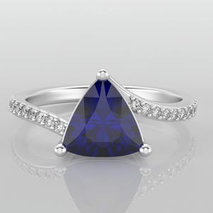 May include: A silver ring with a blue triangular gemstone and a row of small diamonds on the band.