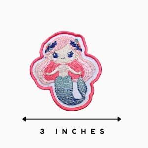 May include: Pink and blue embroidered iron-on patch of a mermaid with a flower crown. The patch is 3 inches wide.
