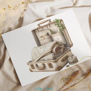 May include: A vintage-style suitcase with a cream and brown color scheme. The suitcase is open and filled with rolled towels and fabric. The suitcase has a brass handle and a brass latch.