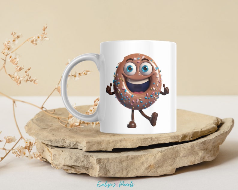 May include: White ceramic mug with a cartoon donut with chocolate frosting and colorful sprinkles. The donut has a smiling face with blue eyes and is giving a thumbs up with both hands.