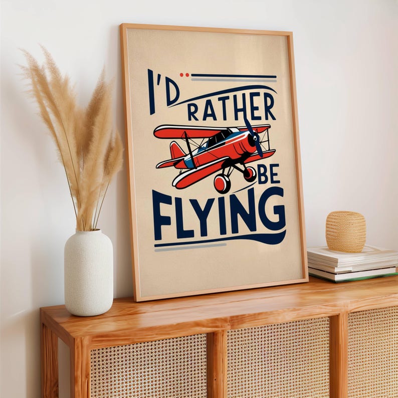 Op de afbeelding: Een vintage poster met een rood vliegtuig en de tekst "I'd rather be flying". De poster heeft een beige achtergrond met blauwe en witte accenten.