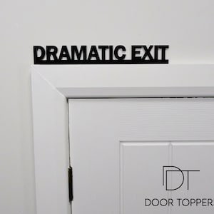 DRAMATIC EXIT Door Topper displayed above a white door frame in black recycled acrylic, ideal as a funny leaving gift or theatre gift.